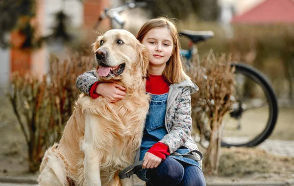 Preteen flicka med golden retriever hund — Stockfoto