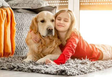 Golden retriever köpeği olan küçük bir kız.