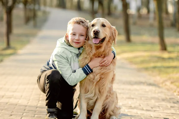 Preteen garçon avec golden retriever chien — Photo