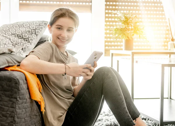 Menina com smartphone em casa — Fotografia de Stock