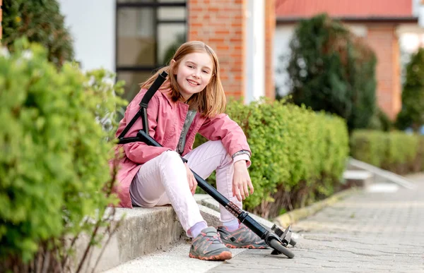 Kleines Mädchen fährt Tretroller — Stockfoto