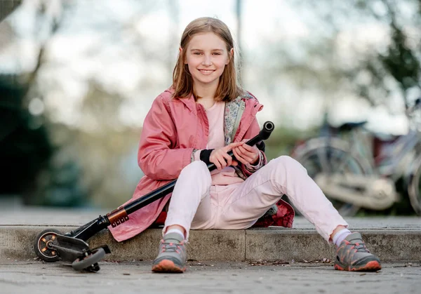 Little girl rides a kick scooter — стоковое фото