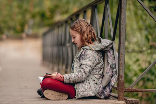 Menina da escola com mochila e livro — Fotografia de Stock