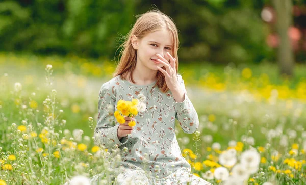 Little Girl Holding Yellow Blowballs Flowers Hands Sitting Blossom Field — Stockfoto