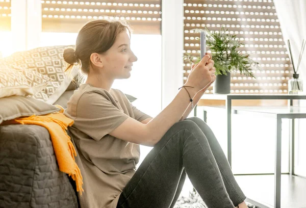 Menina Bonita Senta Com Smartphone Perto Sofá Casa Mulher Adolescente — Fotografia de Stock