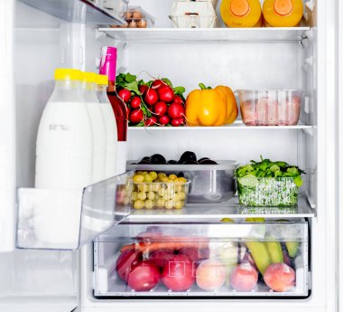 Fridge with fruits and vegetables for healthy vitamin diet. Refrigerator with pumpkin, oranges and grape for vegetarian nutrition
