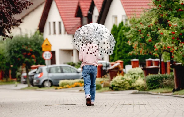 前の女の子の傘を屋外で バックからのビューを歩く かわいい子供の肖像画で雨の日に通り — ストック写真