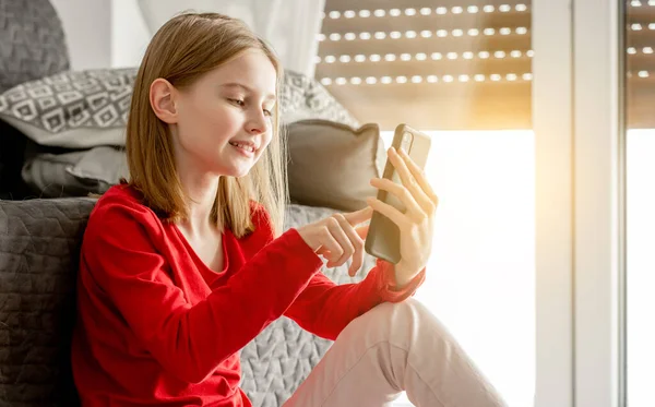 Menina Criança Segura Smartphone Sua Mão Sorri Conversando Com Amigos — Fotografia de Stock