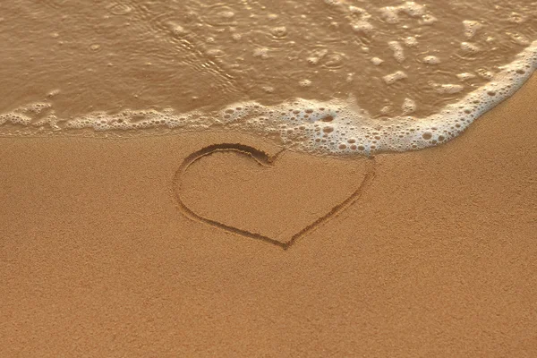 Heart drawing in the sand on the morning beach — Stock Photo, Image