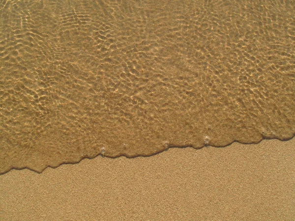 Transparent sea wave on the sand — Stock Photo, Image