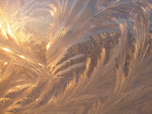Padrão de gelo e luz solar no vidro de inverno — Fotografia de Stock