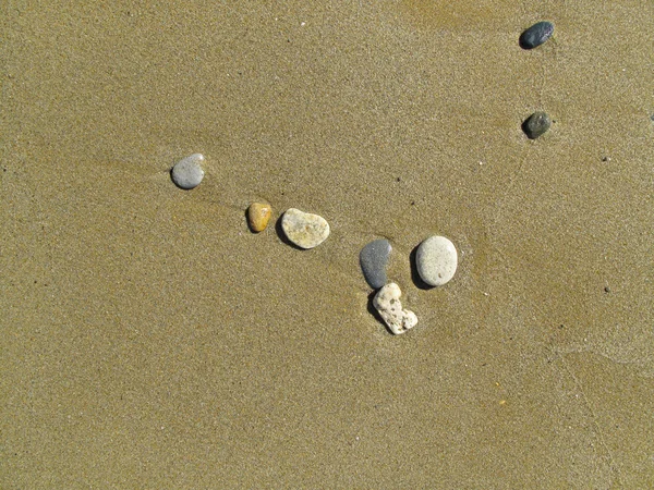 Zand achtergrond met zee steentjes — Stockfoto