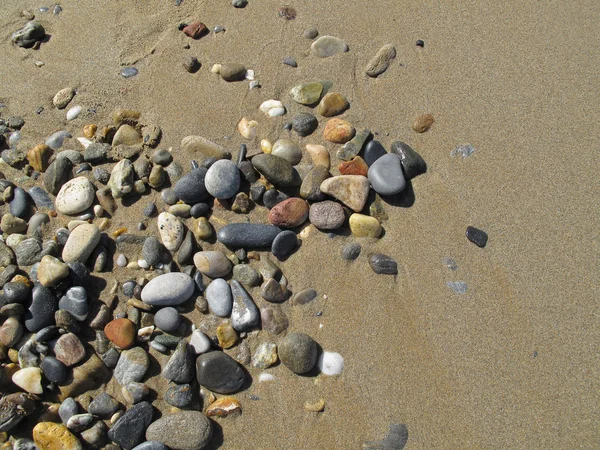 Песчаный фон с галькой — стоковое фото