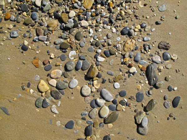 Sandhintergrund mit Meeressteinen — Stockfoto