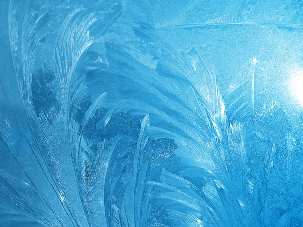 Güzel buz deseni ve güneş ışığı pencereye yakın, doğal mavi kış arkaplanı.