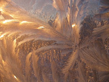 Güzel buz deseni ve güneş ışığı pencere camına yakın, doğal kış arkaplanı.