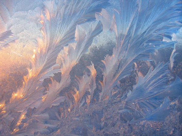 朝早く窓ガラスの上に美しい氷のパターンと太陽の光が閉じられ 自然の冬の背景 — ストック写真