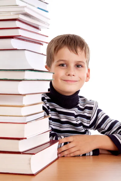 Schooljongen en een hoop boeken geïsoleerd op een witte achtergrond — Stockfoto