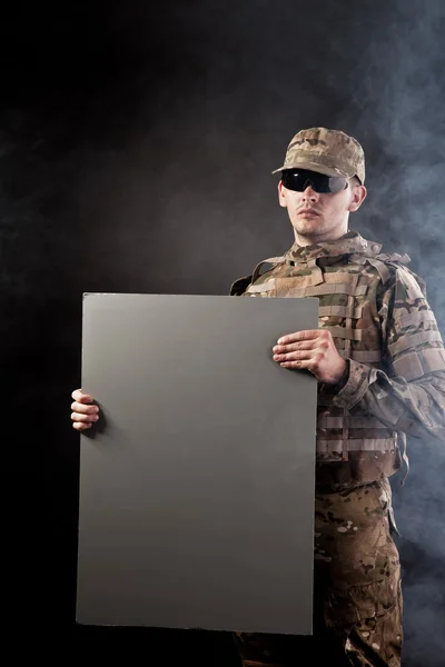 Modern soldier is holding a poster — Stock Photo, Image