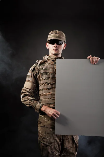 Modern soldier is holding a poster — Stock Photo, Image