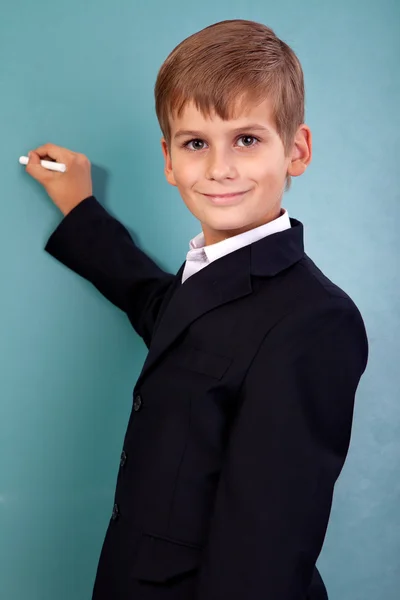 Schoolstudent schrijven op blackboard op school — Stockfoto