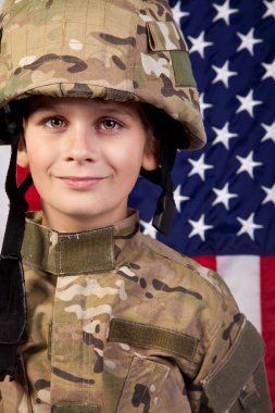 Çocuk ABD askeri Amerikan bayrağı önünde.