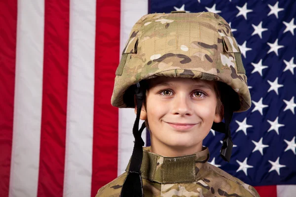 Boy USA soldado na frente da bandeira americana . — Fotografia de Stock