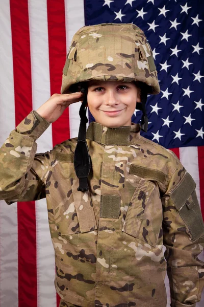 Boy USA soldier saluting in front of American flag.