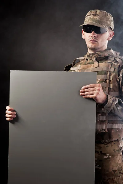 Modern soldier is holding a poster — Stock Photo, Image