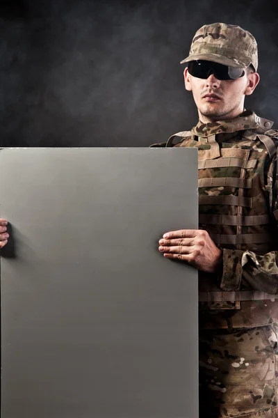 Modern soldier is holding a poster — Stock Photo, Image