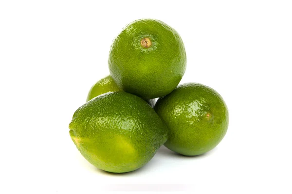 Groupe de limes entières et un demi citron vert sur blanc — Photo