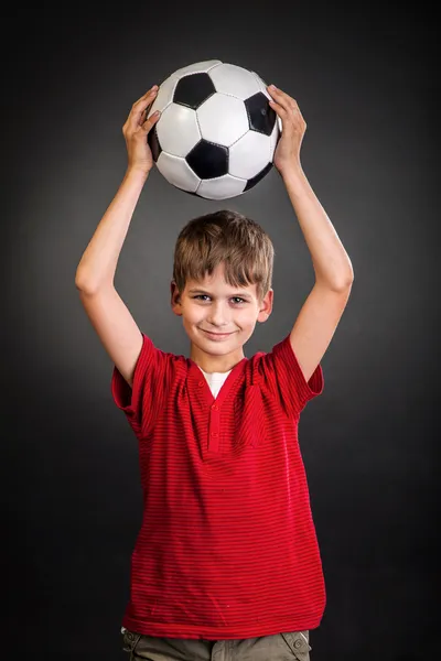 El chico lindo sostiene una pelota de fútbol. Balón de fútbol —  Fotos de Stock