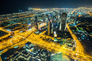 Dubai şehir merkezinde şehir ışıklarıyla dolu bir gece sahnesi,