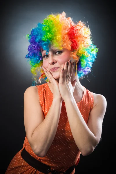 Mulher de peruca de palhaço sorrindo puxando o cabelo falso nas laterais — Fotografia de Stock