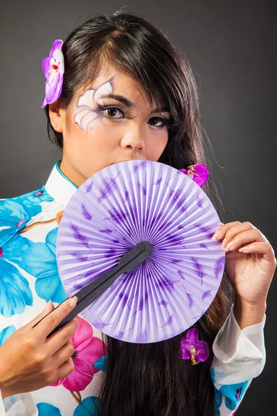 Beautiful asian woman wears a national dress is holding a fan — Stock Photo, Image