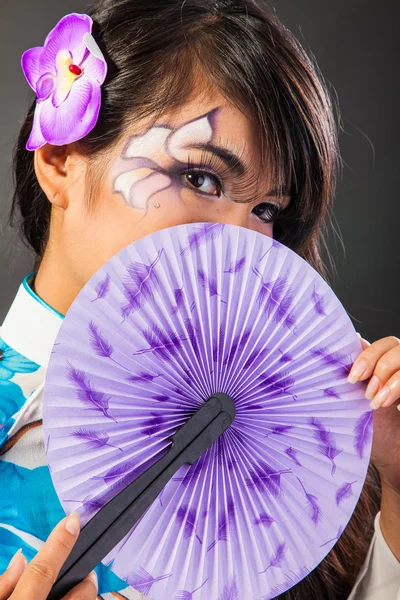 Beautiful asian woman wears a national dress is holding a fan — Stock Photo, Image