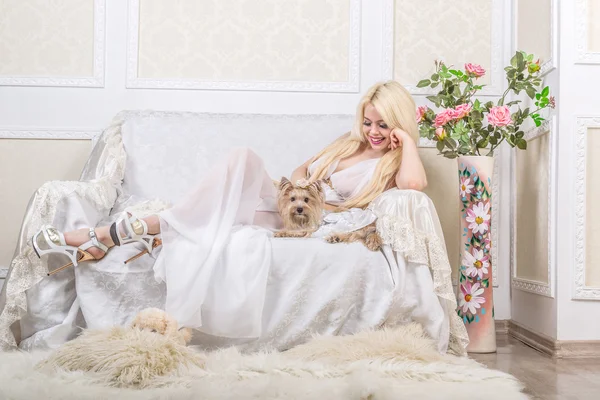 Lujosa mujer rubia en un vestido blanco con un perro pekinés —  Fotos de Stock