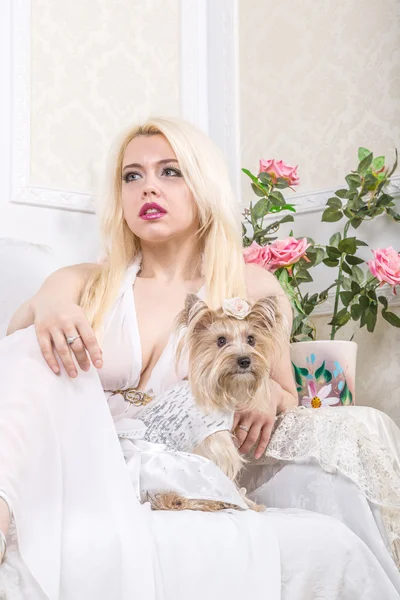 Lyxiga blonda kvinnan i en vit klänning med en hund pekingese — Stockfoto
