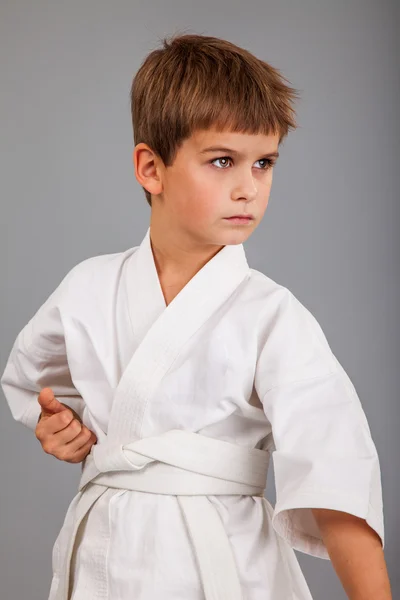 Karate chlapec v bílém kimonu bojuje — Stock fotografie