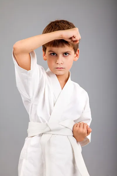 Karate-Junge im weißen Kimono kämpft — Stockfoto