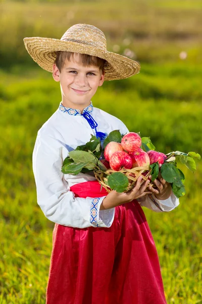 Menino agricultor feliz segurar maçãs orgânicas no jardim de outono — Fotografia de Stock