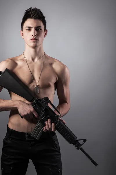 Stilig soldat håller ett gevär — Stockfoto