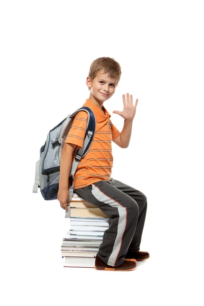 Schoolboy sitting on books — Stock Photo, Image