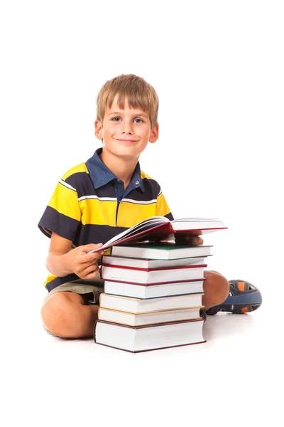 Schoolboy está sentado em livros — Fotografia de Stock