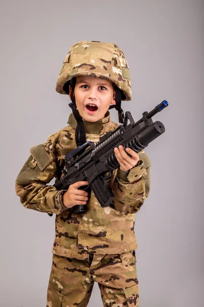 Young boy dressed like a soldier with rifle — Stock Photo, Image