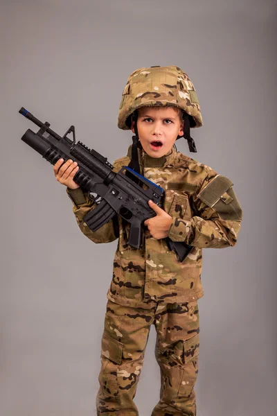 Young boy dressed like a soldier with rifle — Stock Photo, Image