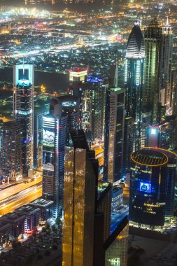 Dubai şehir merkezinde şehir ışıklarıyla dolu bir gece sahnesi,