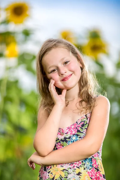 Porträtt av en liten flicka i krans av blommor — Stockfoto