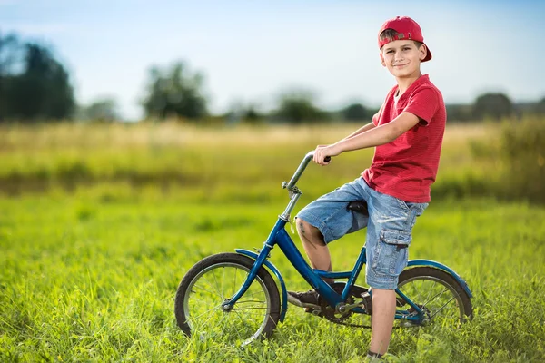 Young boy riding bicycle in a park — Stock Photo, Image