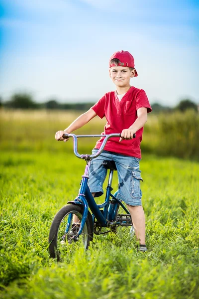 Young boy riding bicycle in a park — Stock Photo, Image